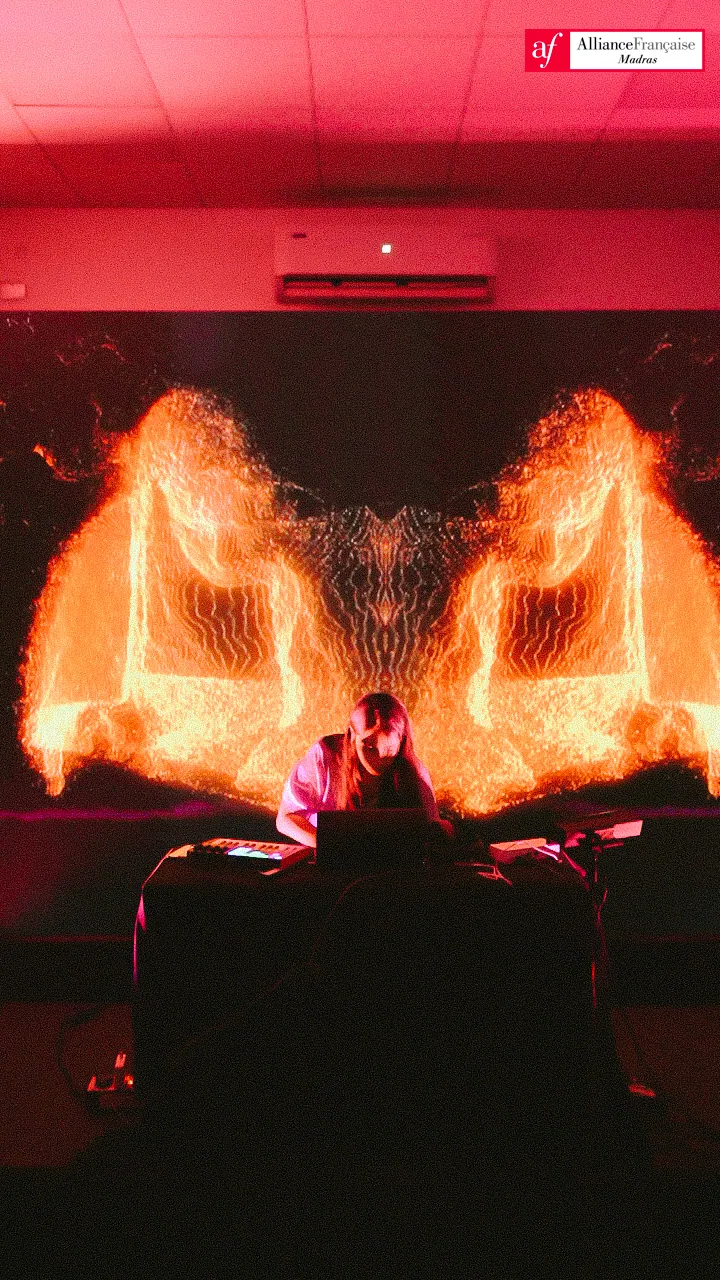 A performer framed by symmetrical orange live visuals at Fête de la Musique.