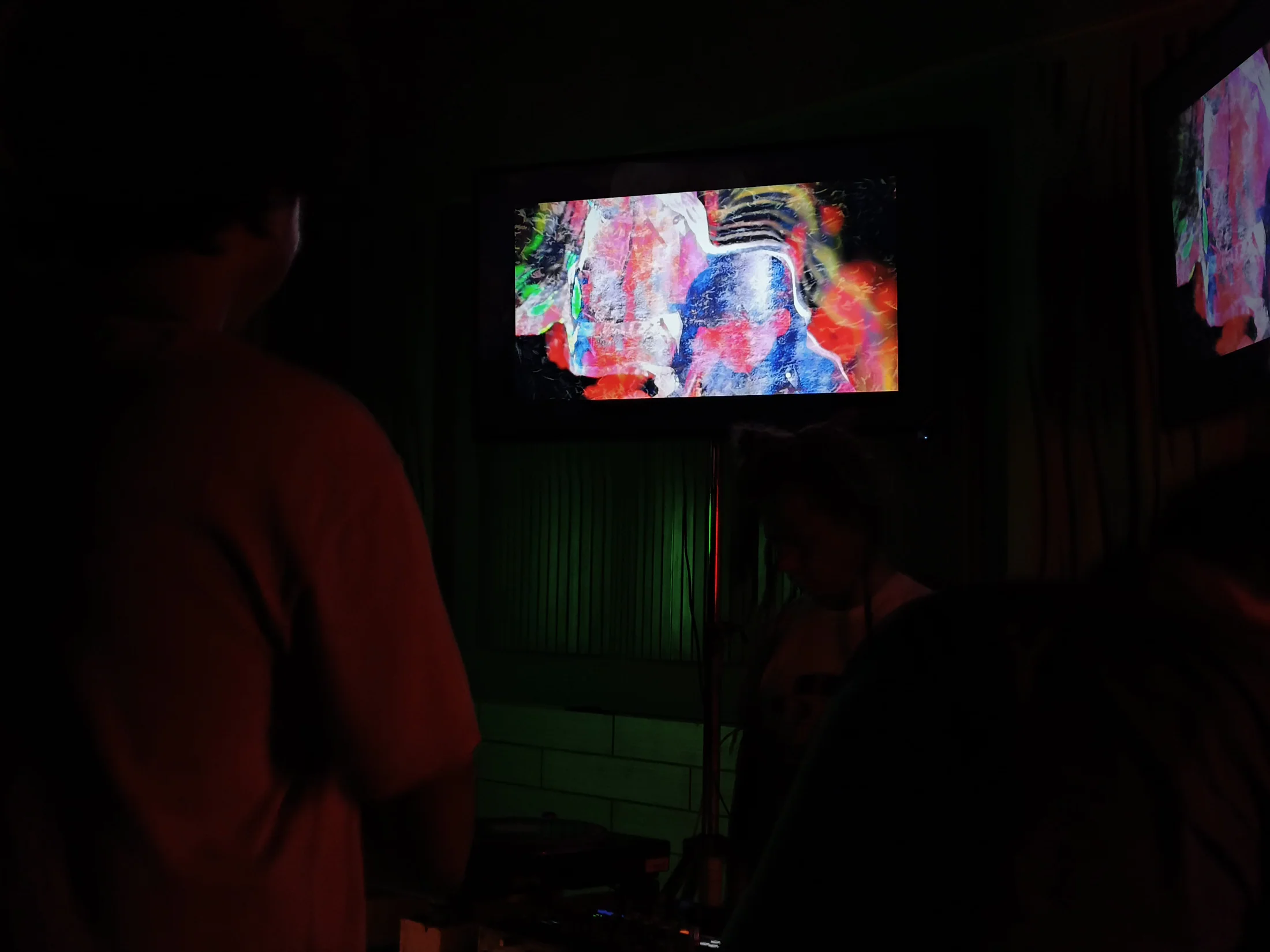 An audience watches layered moving imagery at an Omnivoid edition.